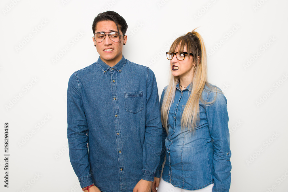Young couple with glasses is a little bit nervous and scared pressing the teeth Young couple with glasses is a little bit nervous and scared pressing the teeth