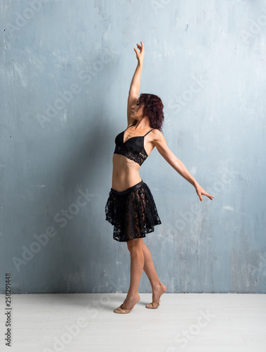 Ballerina dancing on grunge wall background