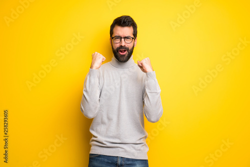 Man with beard and turtleneck celebrating a victory in winner position