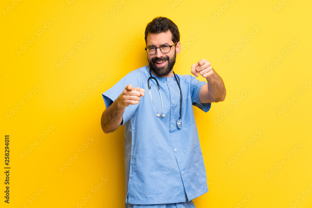 Surgeon doctor man points finger at you while smiling Surgeon doctor man points finger at you while smiling