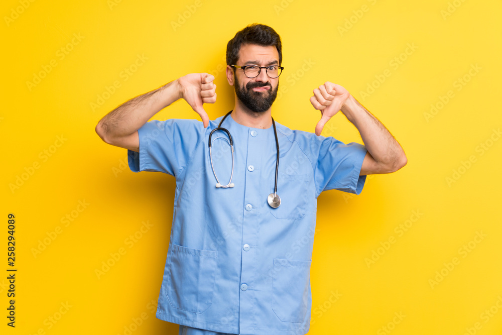 Surgeon doctor man showing thumb down with both hands Surgeon doctor man showing thumb down with both hands