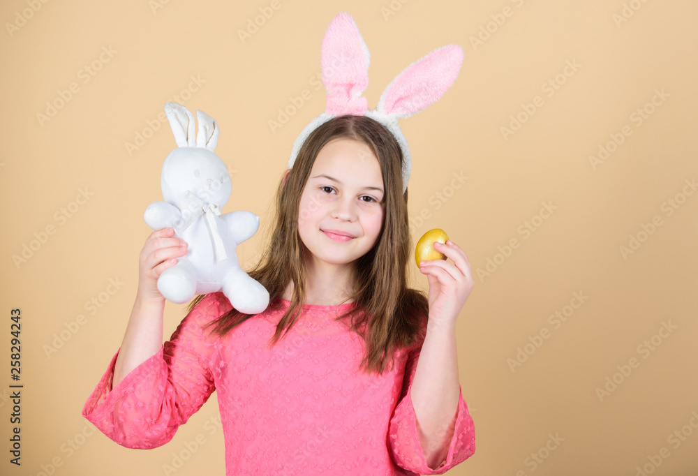 Easter symbols and traditions. Playful child with soft toy. Meet spring holiday. Easter egg hunts as part of festival. Girl little child easter bunny accessory hold dyed egg. Origin of easter bunny Easter symbols and traditions. Playful child with soft toy. Meet spring holiday. Easter egg hunts as part of festival. Girl little child easter bunny accessory hold dyed egg. Origin of easter bunny