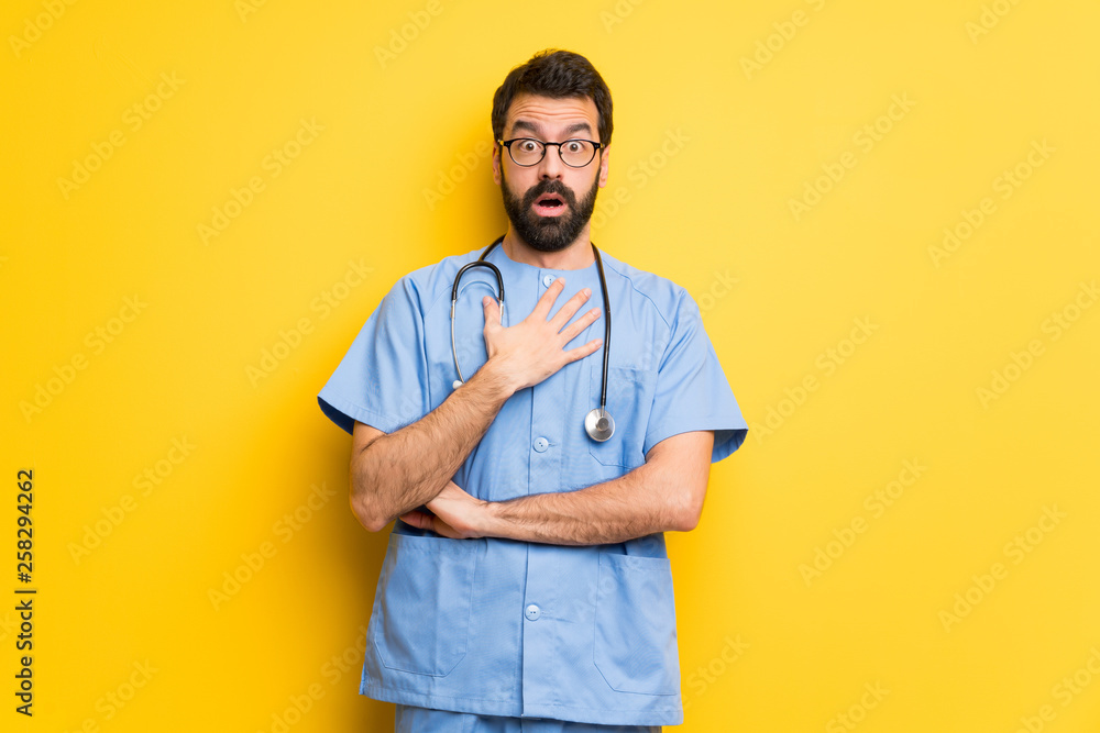 Surgeon doctor man surprised and shocked while looking right Surgeon doctor man surprised and shocked while looking right