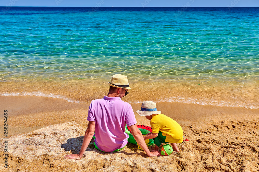 Toddler boy on beach with father Toddler boy on beach with father