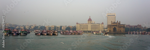 Mumbai city skyline in the evening taken from joy boat ride in the Arabian sea and iconic gateway of india and Taj Mahal hotel in view 