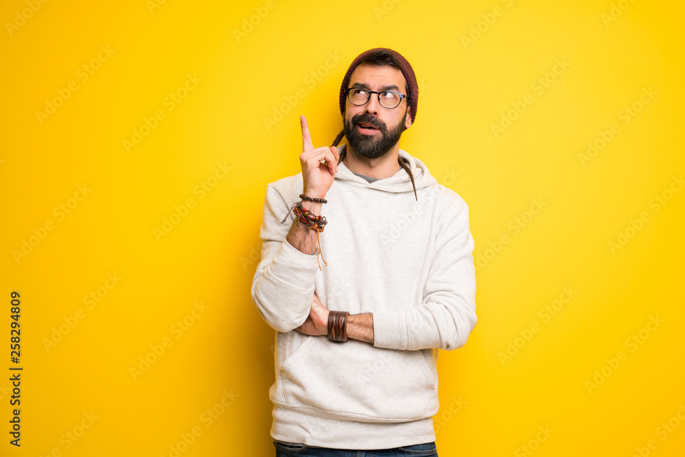 Hippie man with dreadlocks thinking an idea pointing the finger up Hippie man with dreadlocks thinking an idea pointing the finger up