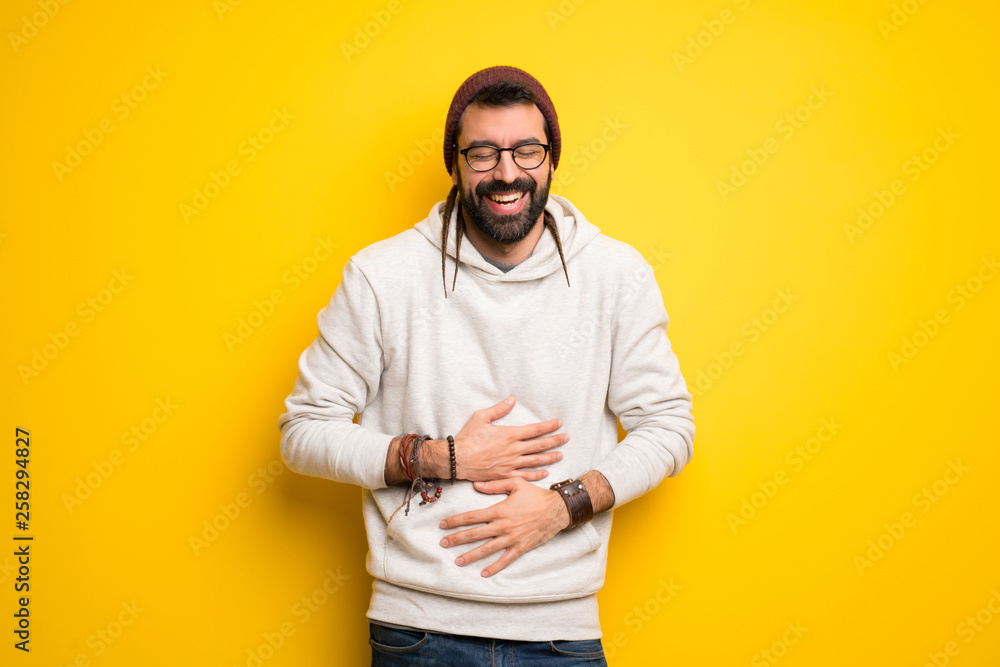 Hippie man with dreadlocks smiling a lot while putting hands on chest Hippie man with dreadlocks smiling a lot while putting hands on chest
