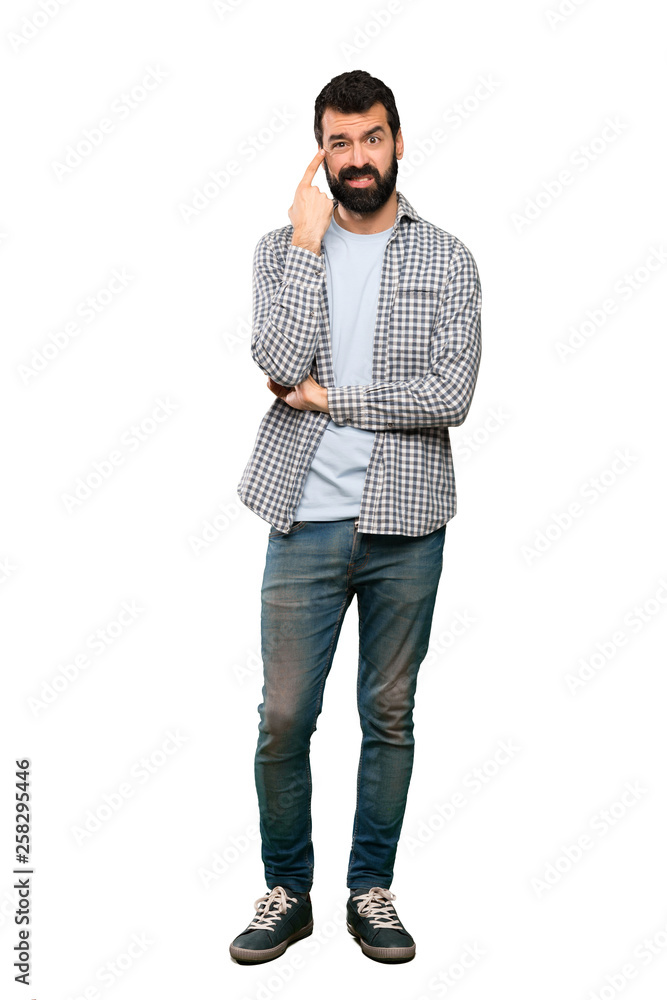 Handsome man with beard making the gesture of madness putting finger on the head over isolated white background Handsome man with beard making the gesture of madness putting finger on the head over isolated white background