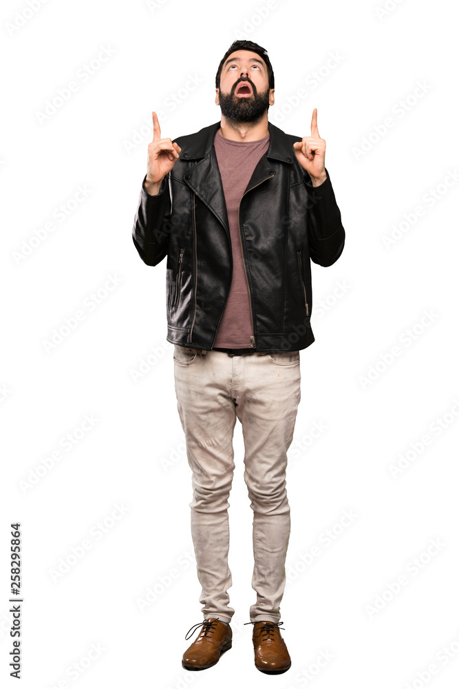 Handsome man with beard surprised and pointing up over isolated white background Handsome man with beard surprised and pointing up over isolated white background