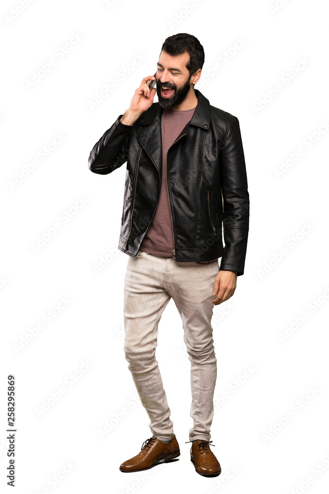 Handsome man with beard keeping a conversation with the mobile phone over isolated white background Handsome man with beard keeping a conversation with the mobile phone over isolated white background