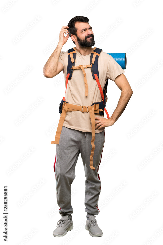Hiker man having doubts while scratching head over isolated white background Hiker man having doubts while scratching head over isolated white background