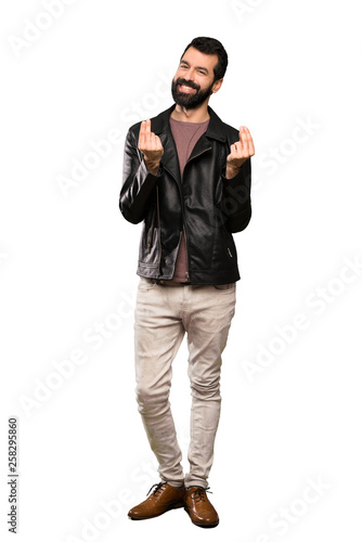 Handsome man with beard making money gesture over isolated white background