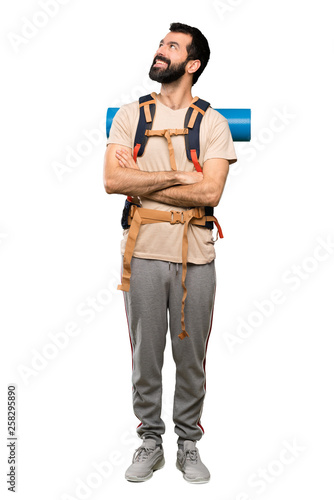 Hiker man looking up while smiling over isolated white background