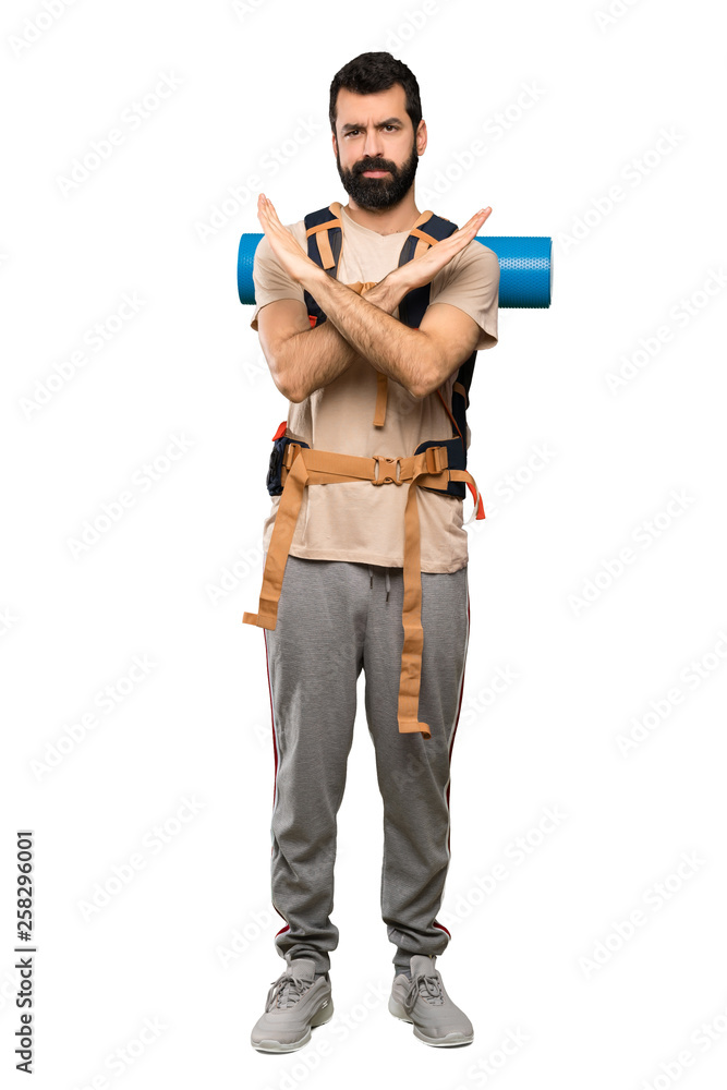 Hiker man making NO gesture over isolated white background Hiker man making NO gesture over isolated white background