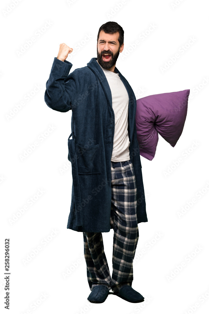 Man with beard in pajamas celebrating a victory over isolated white background Man with beard in pajamas celebrating a victory over isolated white background
