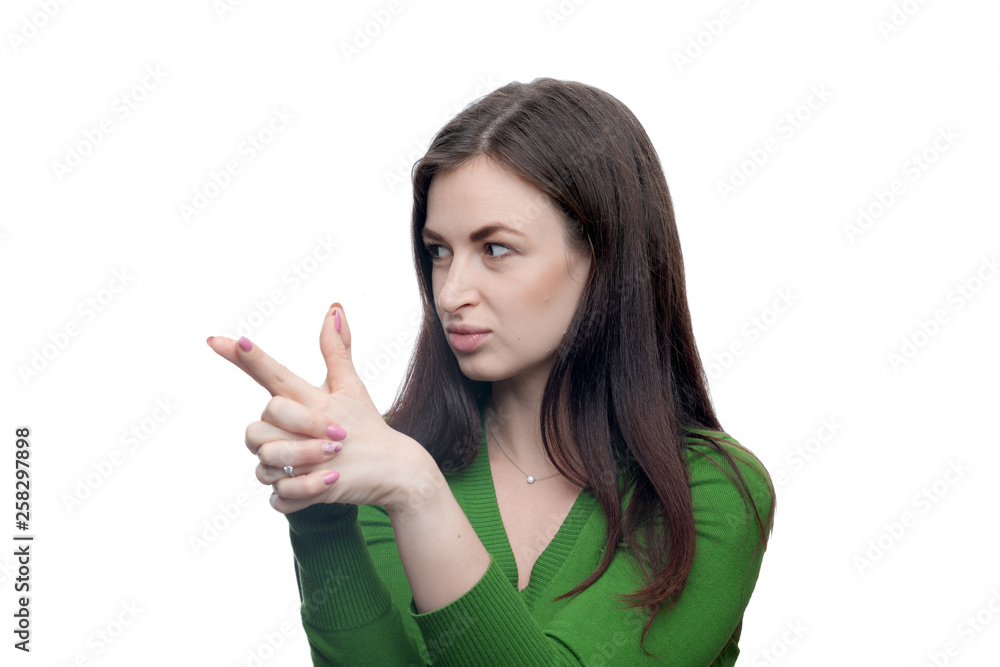 Young brunette woman showing handgun gesture. She wearing green blouse. Studio portrait isolated on white with high resolution. Young brunette woman showing handgun gesture. She wearing green blouse. Studio portrait isolated on white with high resolution.