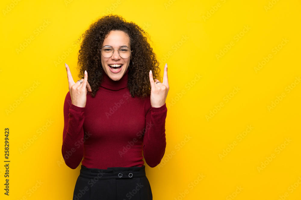 Dominican woman with turtleneck sweater making rock gesture Dominican woman with turtleneck sweater making rock gesture
