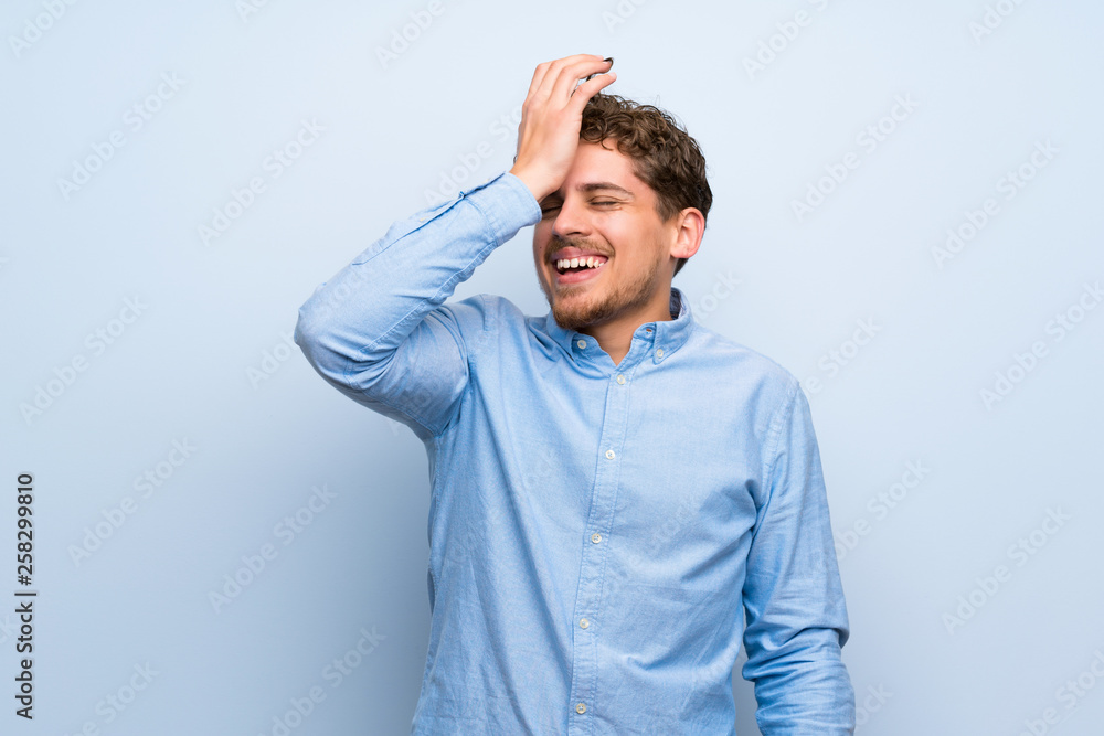 Blonde man over blue wall has realized something and intending the solution Blonde man over blue wall has realized something and intending the solution