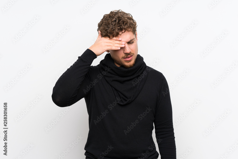 Blonde man over isolated white wall with tired and sick expression Blonde man over isolated white wall with tired and sick expression