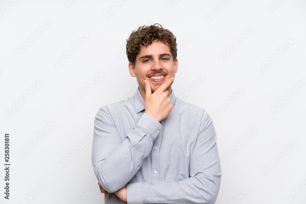Blonde man over isolated white wall laughing Blonde man over isolated white wall laughing