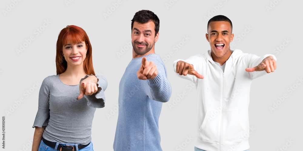 Group of three friends points finger at you Group of three friends points finger at you