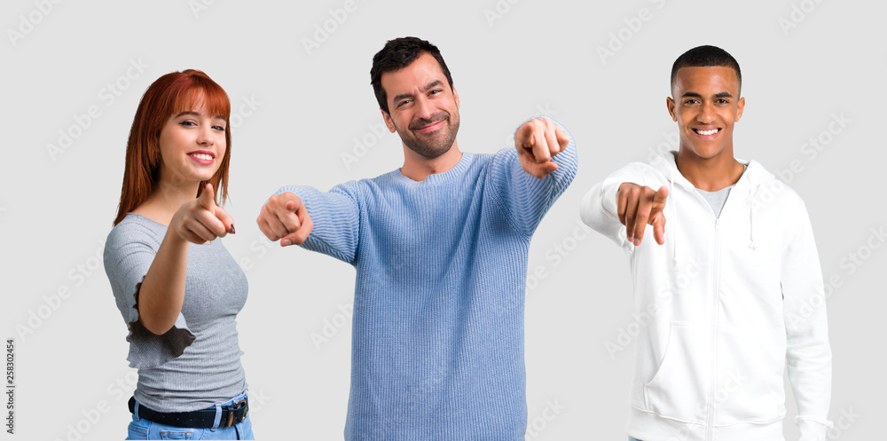 Group of three friends points finger at you Group of three friends points finger at you