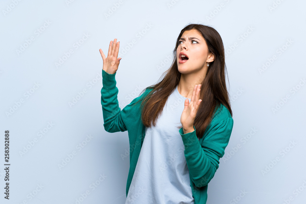 Teenager girl over blue wall nervous and scared Teenager girl over blue wall nervous and scared