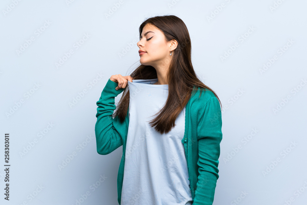 Teenager girl over blue wall with tired and sick expression Teenager girl over blue wall with tired and sick expression