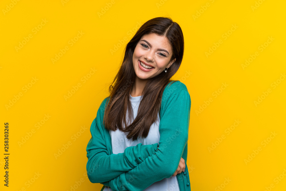 Teenager girl over yellow wall laughing Teenager girl over yellow wall laughing