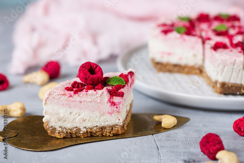 Vegan raw raspberry nut cheesecake on a light  background. Healthy vegan food concept.  Sugar, dairy and gluten free dessert