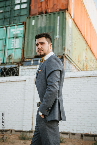 A man in a gray suit poses on the street to advertise men's clothing. Shooting for men's clothing store