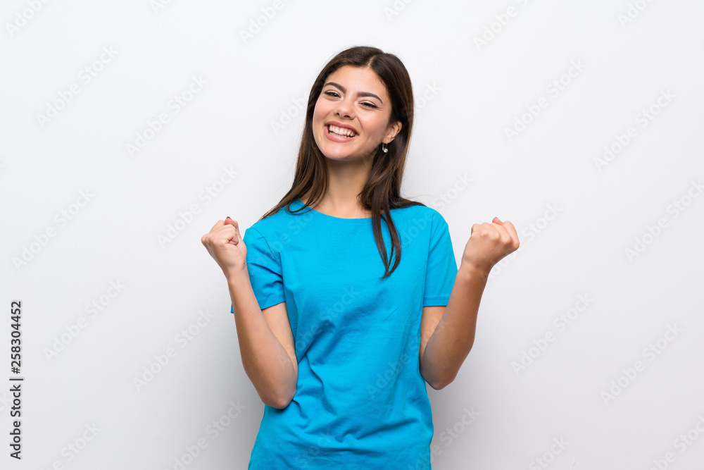 Teenager girl with blue shirt celebrating a victory in winner position Teenager girl with blue shirt celebrating a victory in winner position