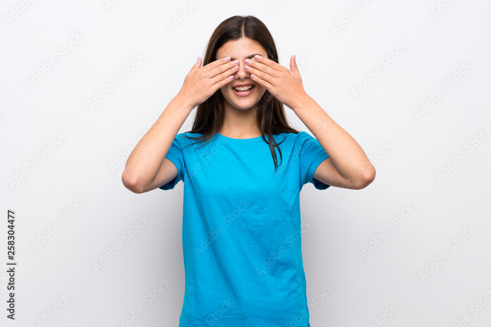 Teenager girl with blue shirt covering eyes by hands Teenager girl with blue shirt covering eyes by hands