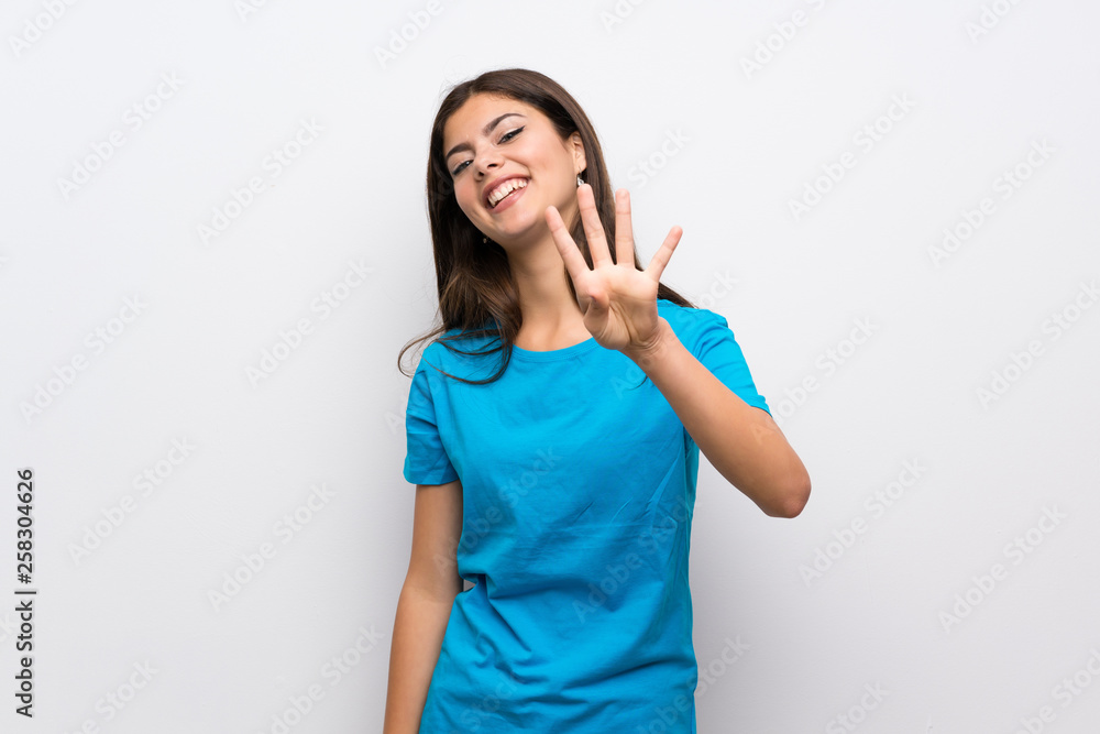 Teenager girl with blue shirt happy and counting four with fingers Teenager girl with blue shirt happy and counting four with fingers
