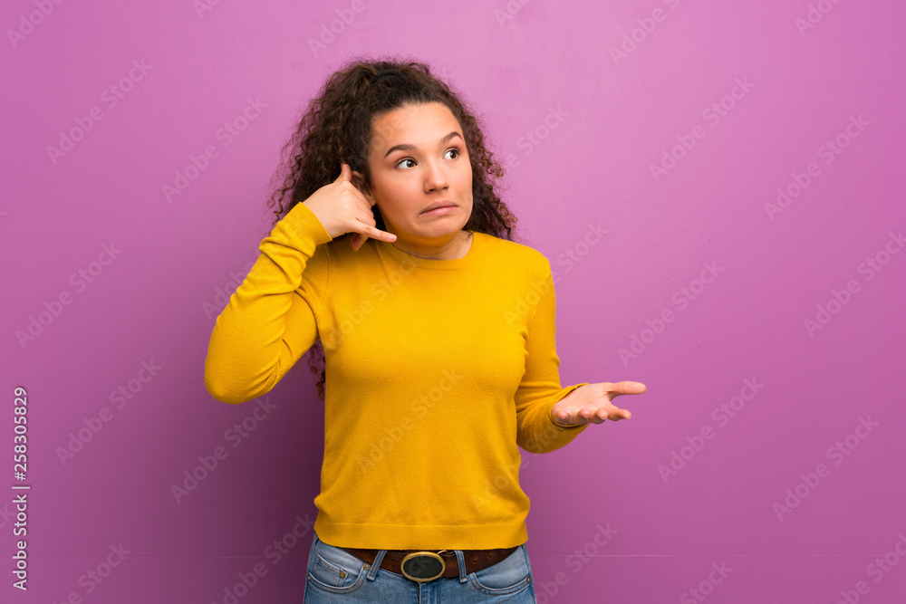 Teenager girl over purple wall making phone gesture and doubting Teenager girl over purple wall making phone gesture and doubting