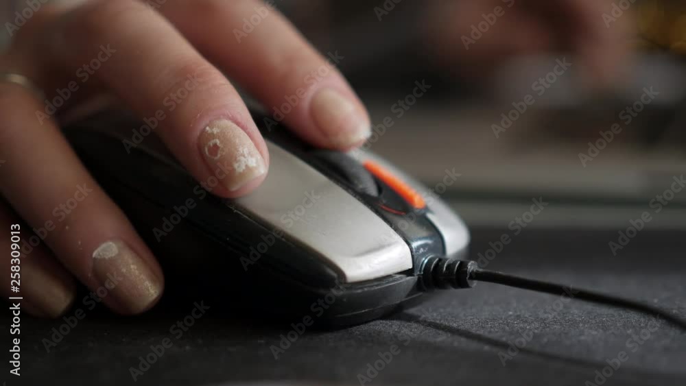 Close-up of a girl with dirty nails using a computer mouse. Close-up of a girl with dirty nails using a computer mouse.