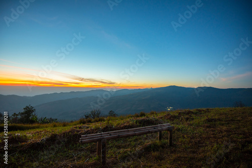 Sunset or sunrise on viewpoint hill mountain yellow and blue sky and bamboo bench