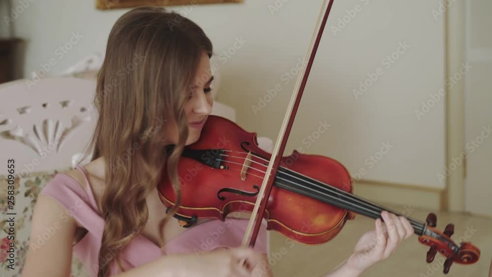 Happy female violinist playing enthusiastically on violin at camera Happy female violinist playing enthusiastically on violin at camera