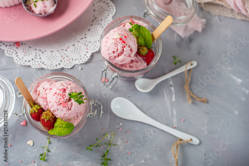 Strawberry ice cream with mint in a glass. Light background