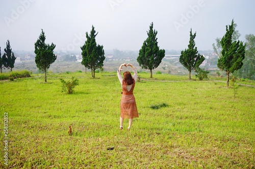 happy young woman jumping in the field © ATIPPORN