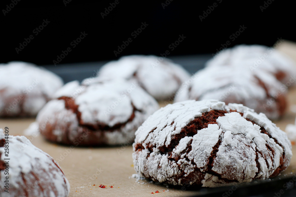 Chocolate cookies with cracks on baking paper and iolated on black. Cracked chocolate biscuits Chocolate cookies with cracks on baking paper and iolated on black. Cracked chocolate biscuits