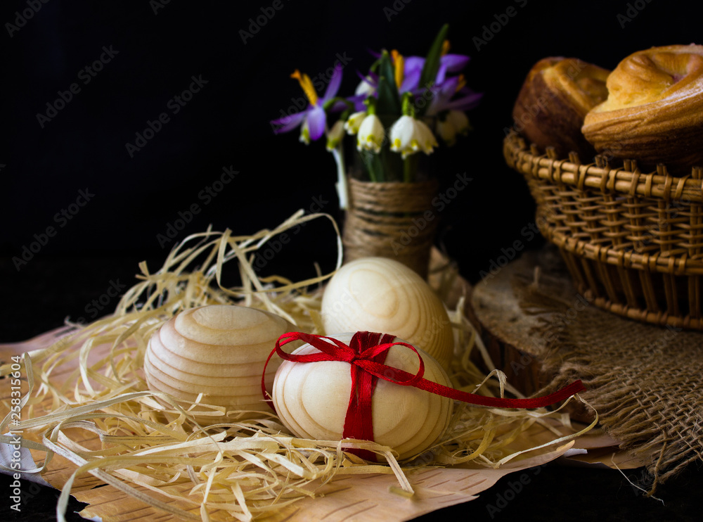 Easter composition with colorful Easter eggs and spring flowers on wooden background. Easter card with copy space.
