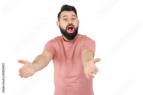 A cute young bearded man in pink shirt shows emotionally happy © romandatso