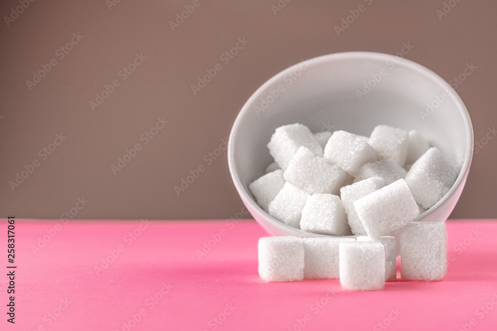 Sugar cubes in a bowl on pink background Sugar cubes in a bowl on pink background