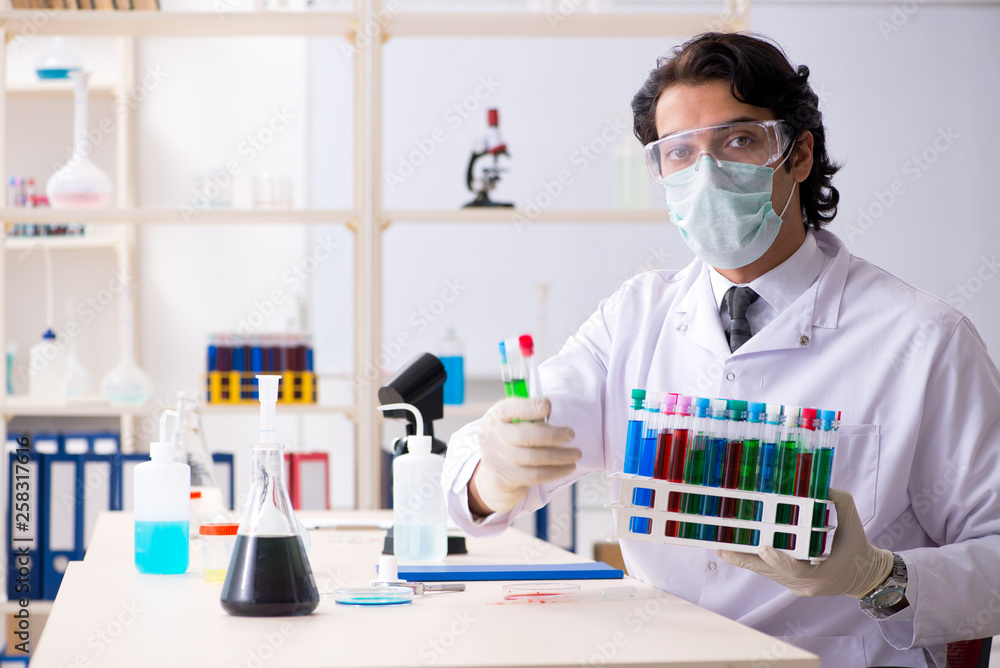 Young handsome chemist working in the lab Young handsome chemist working in the lab