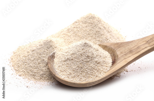 Integral barley flour with wooden spoon isolated on white background