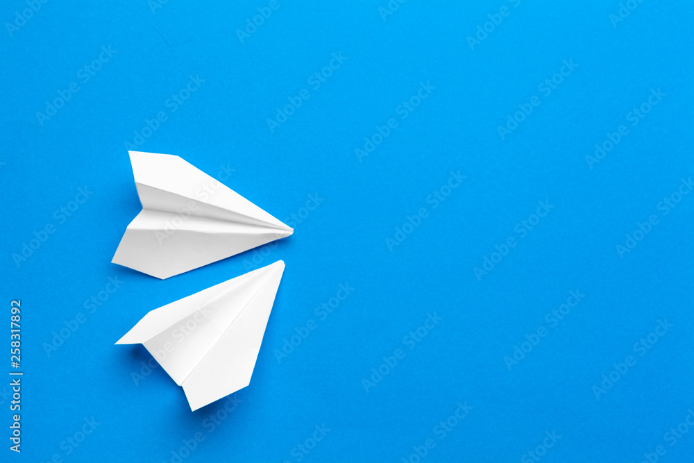 white paper airplane on a navy paper background white paper airplane on a navy paper background