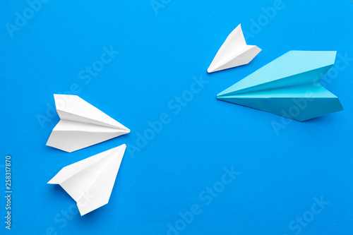 white paper airplane on a navy paper background