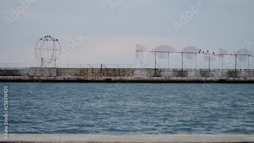 Thessaloniki / Greece 28 march 2019 : the port of thessaloniki.Is spring the weather is clear and the birds are standing to the metal constructions in front of the blue sea