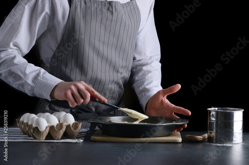 man pouring dough for pie. cake making concept